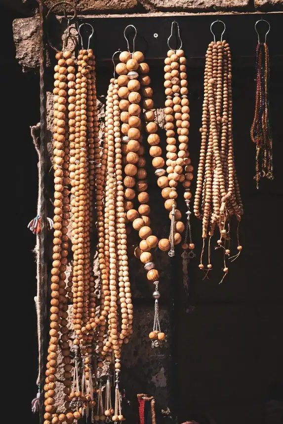 plusieurs chapelets en bois misbaha ou soubha suspendus sur un mur en pierre dans un souk traditionnel