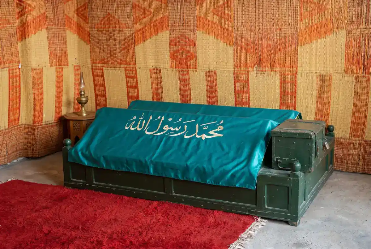 Entrée du mausolée d'Ibn al-Arif à Marrakech, avec sa porte en bois sculpté, ses murs en zelliges colorés et des lanternes traditionnelles.