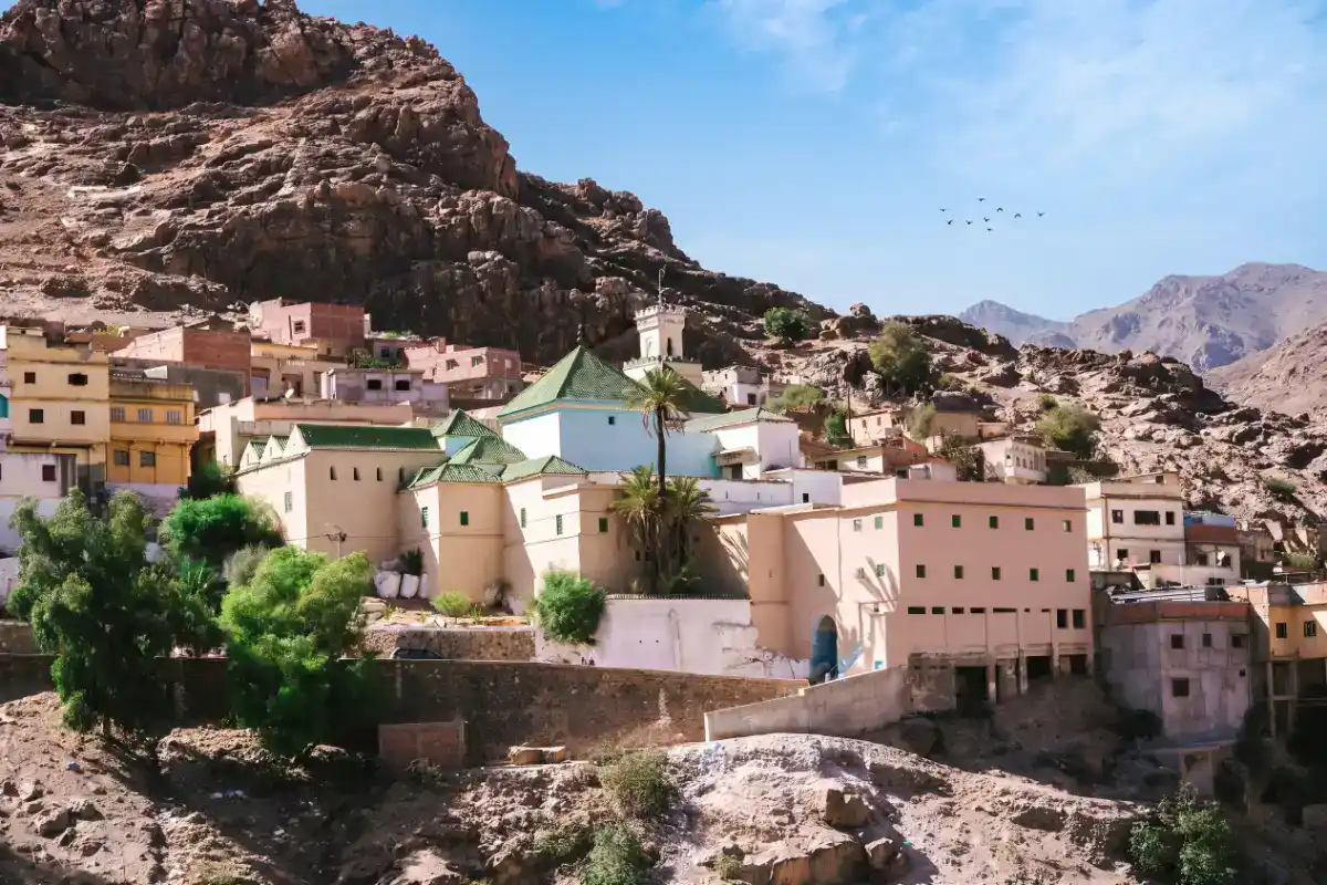 Vue du mausolée de Moulay Bouazza niché dans les montagnes du Moyen Atlas, avec son architecture traditionnelle blanche au cœur d'un village pittoresque.