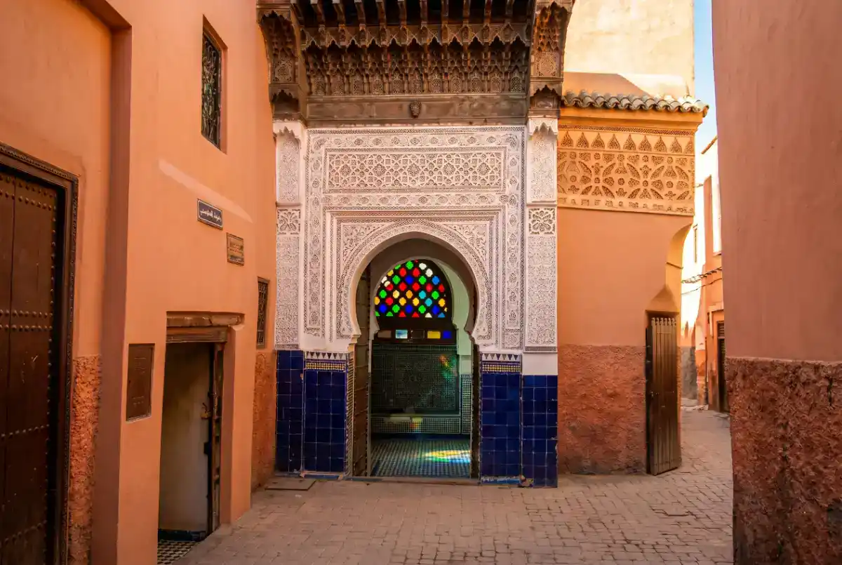 Détails architecturaux du mausolée de Sidi Abdelaziz Tebbaâ à Marrakech, montrant les zelliges traditionnels et le travail du bois sculpté.