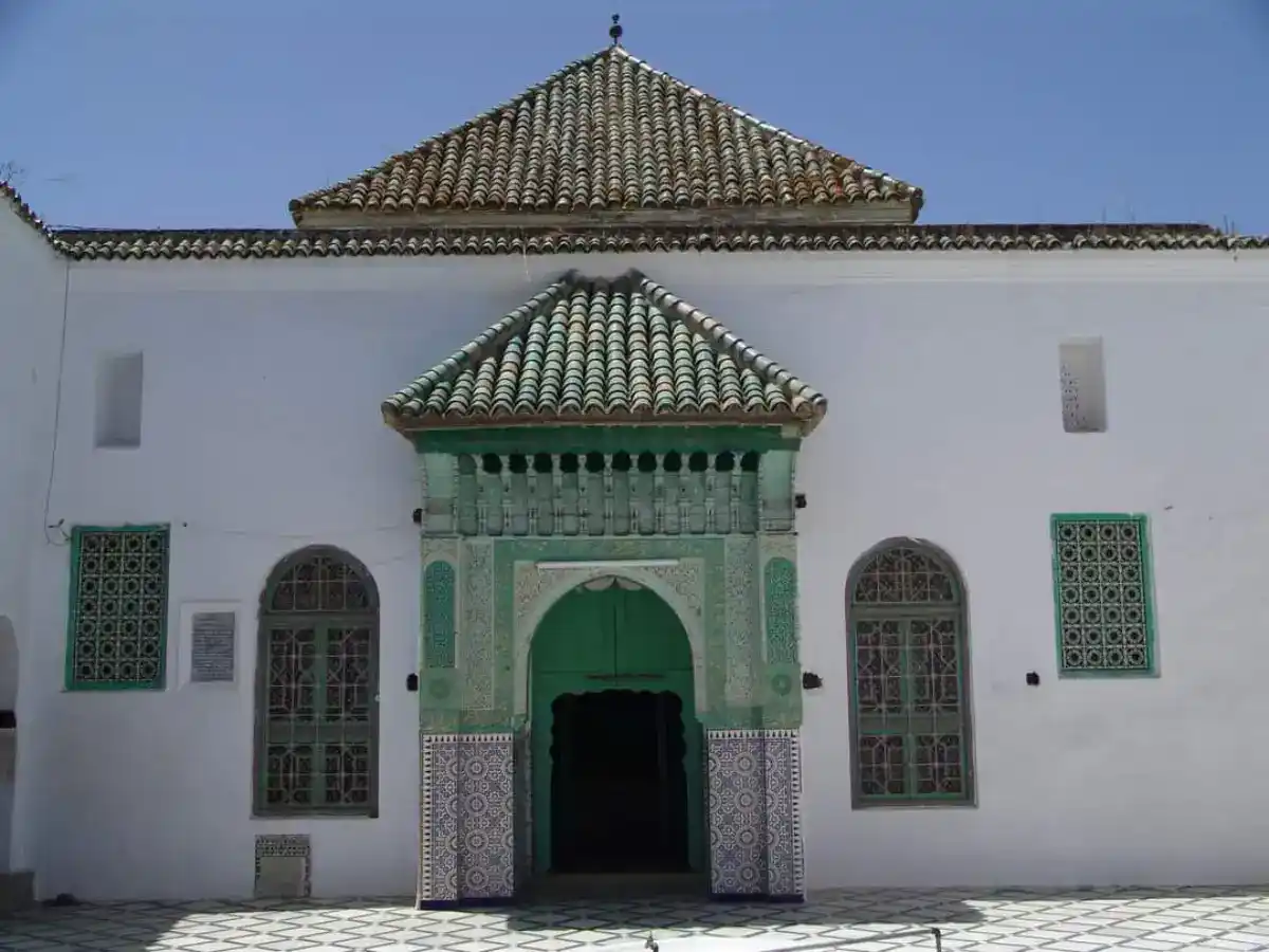 Entrée du mausolée de Sidi Boughaleb à Ksar El Kébir, avec son architecture traditionnelle, ses murs blancs et son dôme en tuiles vertes.