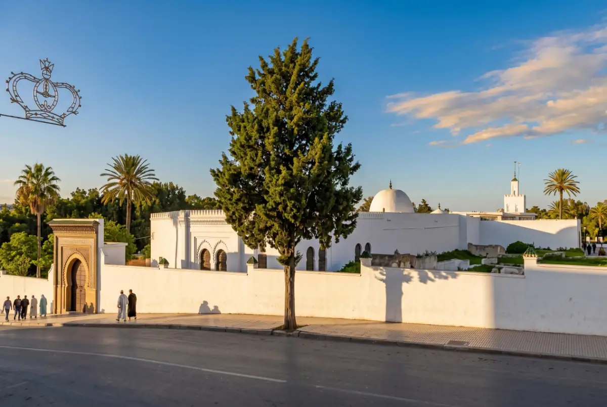 Vue du minaret richement décoré et du dôme du mausolée de Sidi Bouarrakia à Tanger, avec ses mosaïques de zelliges verts et ses motifs géométriques.