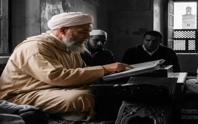 savant de la région du Souss en djellaba et turban, enseignant les sciences islamiques à des étudiants attentifs dans une école traditionnelle (madrassa) au Maroc.