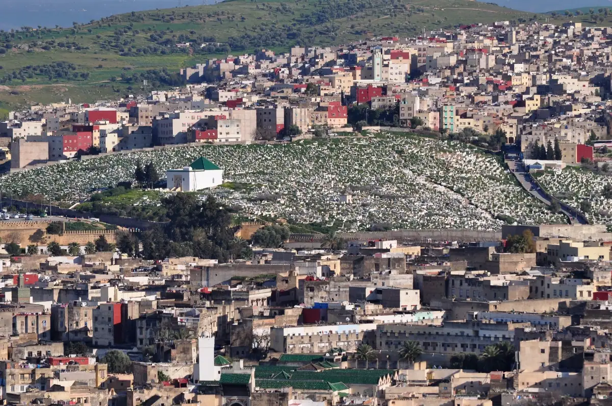 Mausolée blanc au toit vert de Khayrouna al-Fassia au cœur du cimetière de Bab Ftouh, surplombant la médina de Fès.
