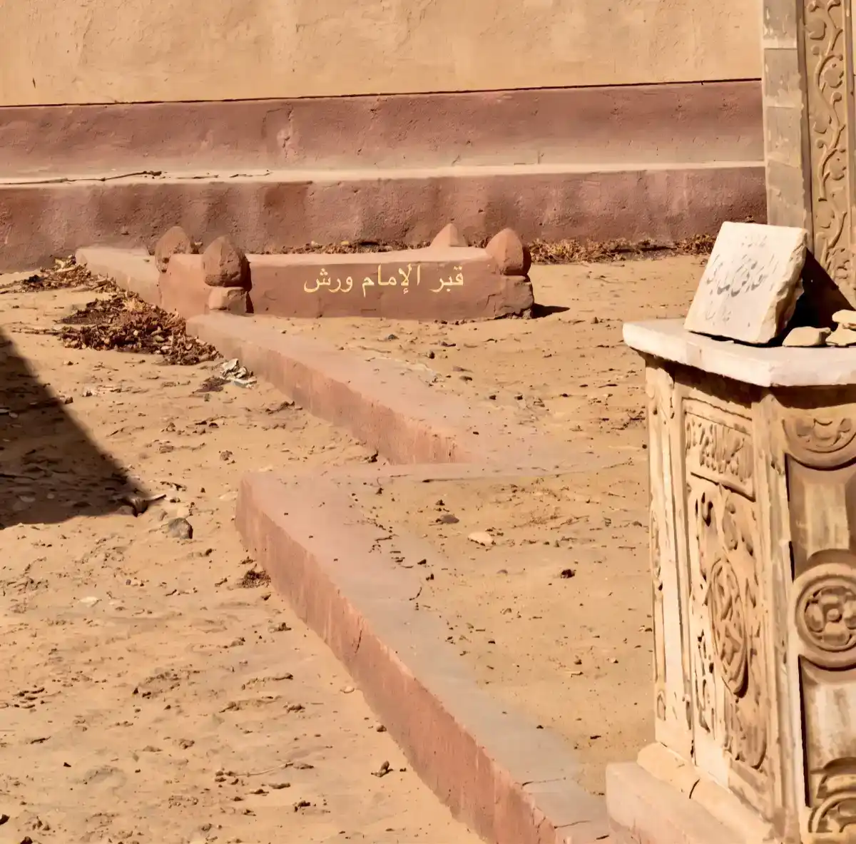 Vue de la tombe de l'Imam Warch. L'inscription en arabe lisible sur la structure indique « Tombe de l'Imam Warch » (قبر الإمام ورش).
