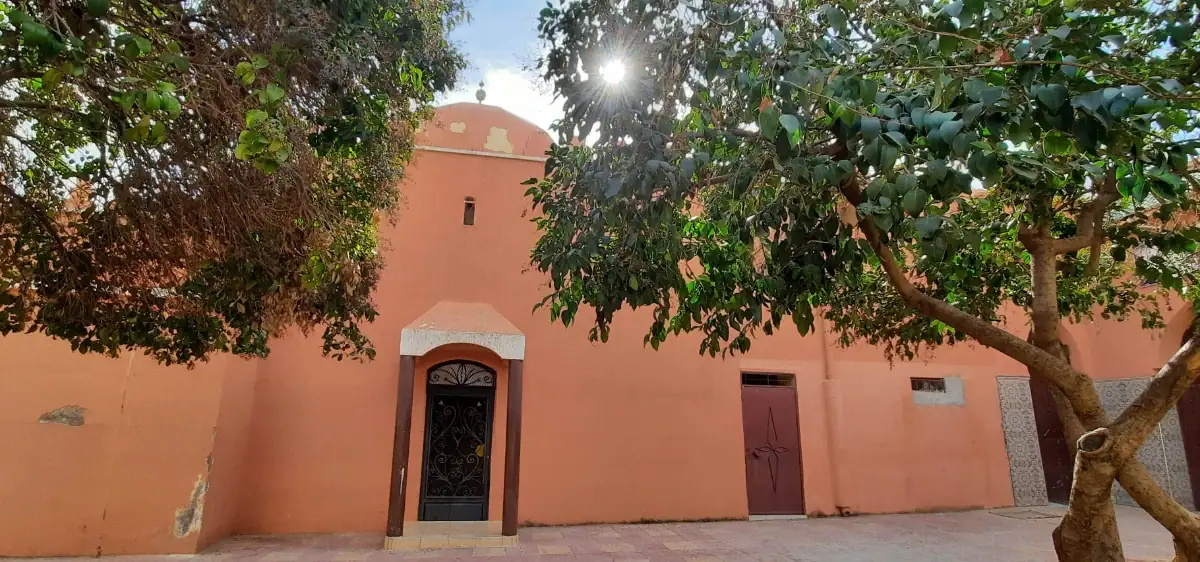 Façade de la Zaouïa d'Ahmed al-Tādilī al-Sawmaʿī à Béni Mellal avec coupole et arbres